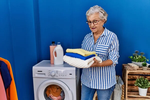 Senior Mulher Cabelos Grisalhos Sorrindo Confiante Segurando Roupas Dobradas Lavanderia — Fotografia de Stock