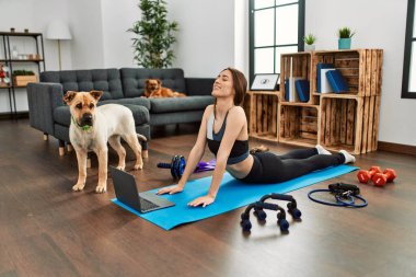 Evde esneme kursu aldığından emin bir şekilde gülümseyen genç İspanyol kadın.