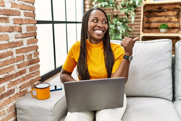 Африканская Женщина Сидит Диване Используя Ноутбук Дома Улыбается Счастливым Лицом — стоковое фото