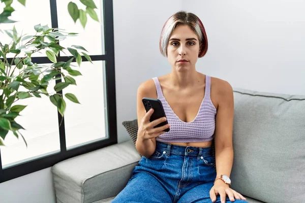 Jovem Mulher Bonita Usando Mensagem Digitação Smartphone Sentado Sofá Cético — Fotografia de Stock