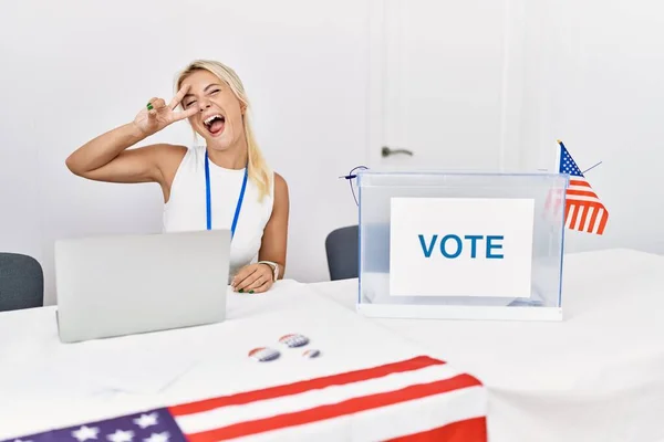 アメリカの政治運動の選挙で若い白人女性が顔の上に指で平和のシンボルをやって 勝利を示す陽気に笑顔 — ストック写真
