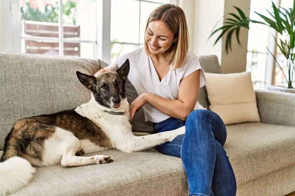 Jovem Caucasiana Sorrindo Feliz Sentado Sofá Com Cão Casa — Fotografia de Stock