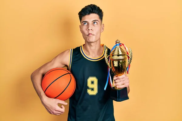 Молодой Латиноамериканец Носящий Баскетбольную Форму Держит Мяч Делает Рыбье Лицо — стоковое фото