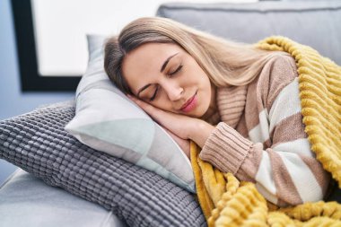 Young woman lying on sofa sleeping at home