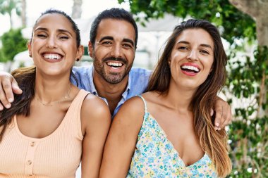 Üç İspanyol arkadaş şehirde mutlu bir şekilde gülüyor ve sarılıyorlar..