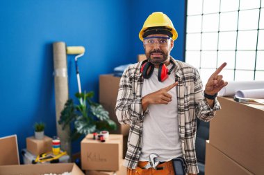 Evde sakallı ve sakallı genç adam endişeli ve gergin olduğunu ve endişeli ve şaşırmış bir ifade takındığını gösteriyor. 