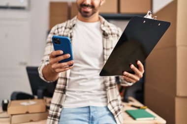 Genç bir İspanyol iş adamı ofisteki akıllı telefon okuma belgesini kullanıyor.