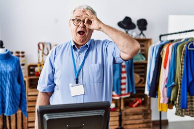 Gri saçlı, perakende mağazasında müdür olarak çalışan yaşlı adam şaşırmış yüz ifadesiyle şaşırmış, parmaklarından bakan bir jest yapıyor. İnançsız ifade. 