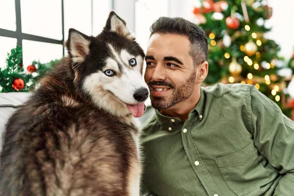 Evdeki Noel Ağacının Yanında Köpekle Kanepede Otururken Kendine Güvenen Spanyol — Stok fotoğraf
