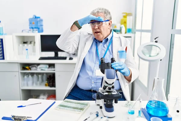 科学研究所で働いている高齢者の白人男性は 頭の上を手で遠くを見て非常に幸せと笑顔 検索の概念 — ストック写真