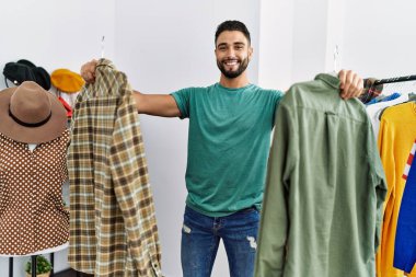 Genç Arap müşteri kıyafet mağazasında kendine güvenen bir alışveriş yapıyor.
