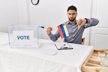 Siyasi seçim kampanyasında sakallı, kızgın yüzlü, Venezuela bayrağı tutan genç yakışıklı bir adam. 