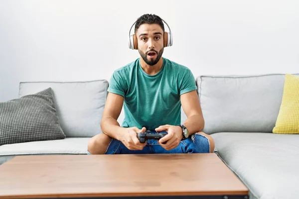 Snygg Hispanic Man Bär Hörlurar Spelar Spel Innehav Controller Rädd — Stockfoto