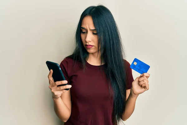 Ung Latinamerikansk Flicka Håller Smartphone Och Kreditkort Deprimerad Och Oroa — Stockfoto