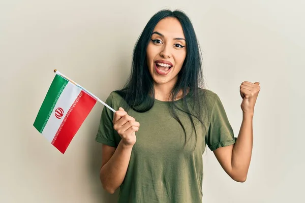 Young Hispanic Girl Holding Iran Flag Pointing Thumb Side Smiling — Stock Photo, Image