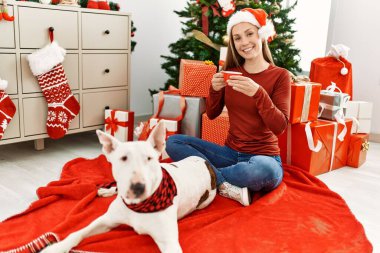 Kafkasyalı genç bir kadın evde köpekle oturup kahve içiyor.