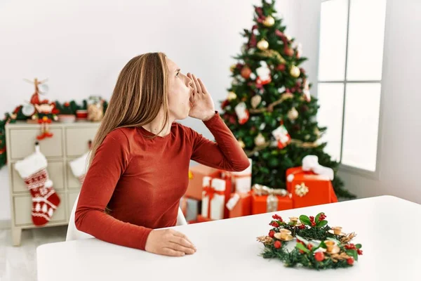Kavkazská Mladá Blondýnka Sedící Stole Vánočního Stromku Křičící Křičící Stranu — Stock fotografie