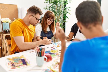 Resim stüdyosunda çizim yapan bir grup insan..