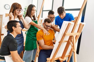 Mutlu gülümseyen ve ortak arayan bir grup insan sanat stüdyosunda..