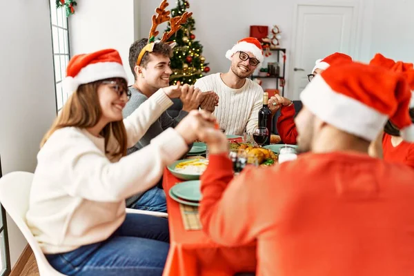 Grupo Jóvenes Celebrando Navidad Rezando Por Comida Sentados Mesa Casa —  Fotos de Stock