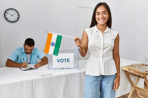 Young indian voter woman smiling happy holding india flag at electoral college.