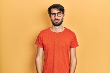 Gündelik kıyafetler ve gözlük takan genç İspanyol adam üzgün ve endişeli, sinirli ve korkmuş. hüzünlü ifade. 