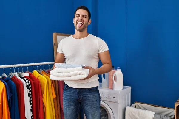 若いですヒスパニック男とともに髭保持折り畳まれたきれいなタオルで洗濯物部屋に突き出し舌幸せなアウト面白い式 — ストック写真