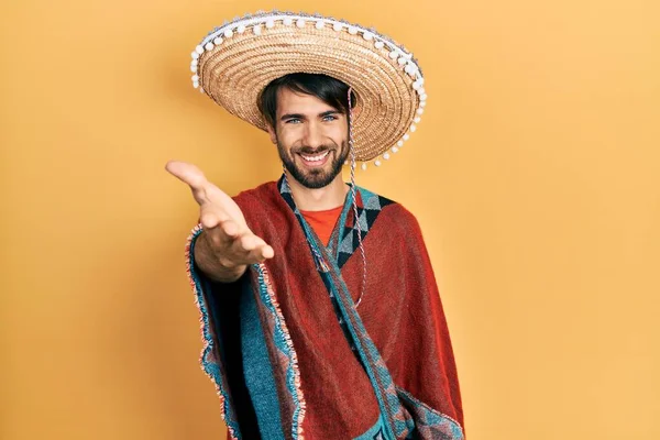 Jovem Hispânico Segurando Chapéu Mexicano Sorrindo Oferta Amigável Aperto Mão — Fotografia de Stock