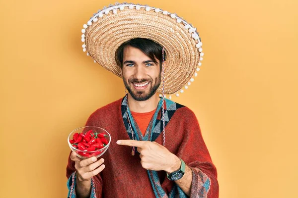 Jovem Hispânico Usando Chapéu Mexicano Segurando Chili Sorrindo Feliz Apontando — Fotografia de Stock