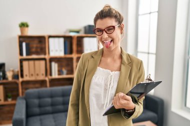 Muayenehanede çalışan genç bir kadın komik bir ifadeyle dilini dışarı çıkartıyor. duygu kavramı. 