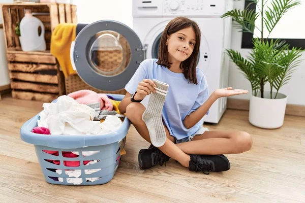 Ung Latinamerikansk Flicka Gör Tvätt Hålla Strumpor Pekar Sidan Med — Stockfoto