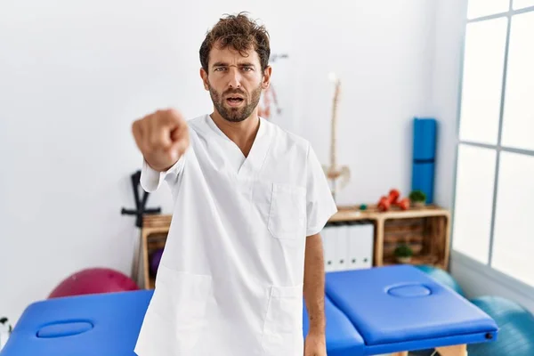Young Handsome Physiotherapist Man Working Pain Recovery Clinic Pointing Displeased — ストック写真