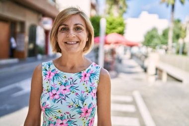 Orta yaşlı, güzel bir kadın parkta kendine güvenen.