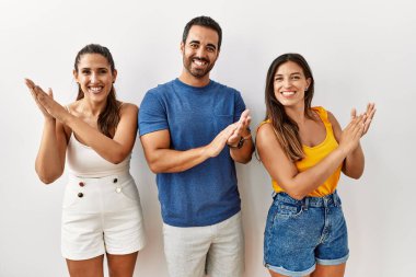 Bir grup İspanyol genç arka planda ayakta alkışlıyor ve mutlu ve neşeli alkışlıyor, gururla gülümsüyor. 