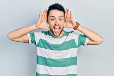 Gündelik giysiler giyen, neşeli gülümseyen, ellerini göstererek bir yuhalama oynayan İspanyol bir genç. Şaşırdım ve çıktım. 