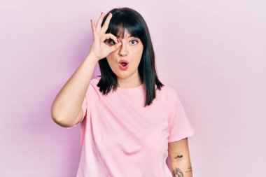 Gündelik kıyafetler giyen genç İspanyol kadın şaşırmış yüz ifadesiyle şok olmuş, parmaklarından bakan gözler. İnançsız ifade. 