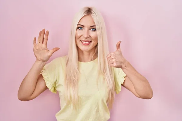 Blanke Vrouw Staande Roze Achtergrond Tonen Wijzen Met Vingers Nummer — Stockfoto