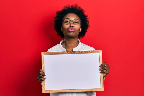 Młoda Afroamerykanka Trzymająca Pustą Białą Tablicę Patrząca Kamerę Dmuchająca Pocałunek — Zdjęcie stockowe