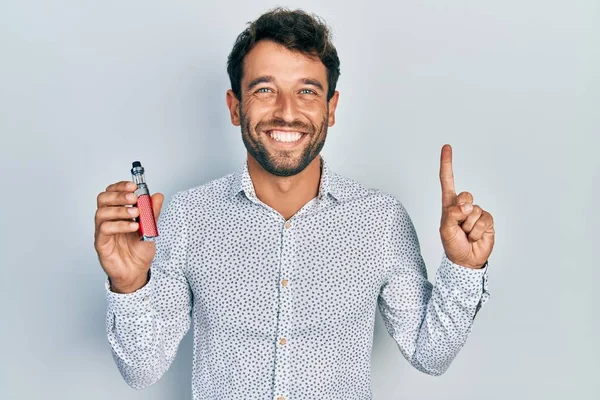 Красивий Чоловік Бородатим Футбольним Репортером Тримає Електронну Сигарету Посміхаючись Ідеєю — стокове фото