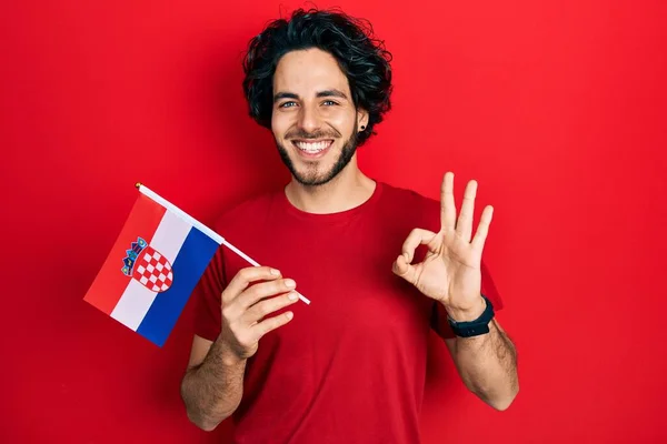 Bonito Hispânico Homem Segurando Bandeira Croácia Fazendo Sinal Com Dedos — Fotografia de Stock