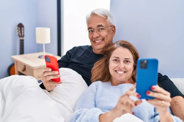 Medelålders Man Och Kvinna Par Med Hjälp Smartphone Liggande Sängen — Stockfoto