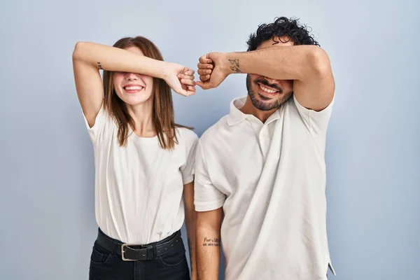 若いカップル一緒に腕を笑顔で陽気で面白い目をカバー立ってカジュアルな服を着て 視覚障害の概念 — ストック写真