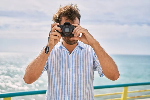 Ung Latinamerikansk Man Ler Glad Med Kameran Stranden — Stockfoto