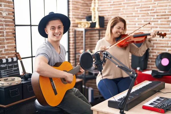 男性と女性の音楽家は音楽スタジオでバイオリンとクラシックギターを演奏 — ストック写真