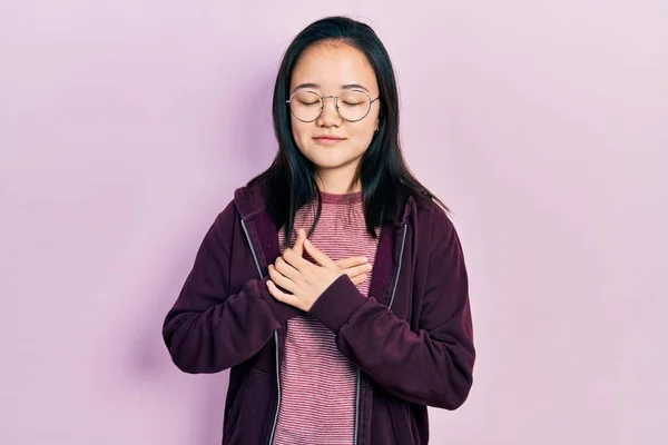 Молодая Китаянка Повседневной Одежде Очках Улыбается Закрытыми Глазами Груди Благодарным — стоковое фото
