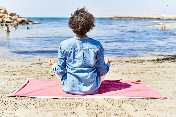 年轻的惊慌失措的男人坐在沙滩上做瑜伽放松 — 图库照片