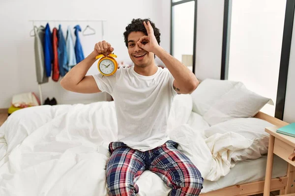 Junge Hispanische Mann Mit Wecker Sitzt Auf Dem Schlafzimmer Lächelnd — Stockfoto