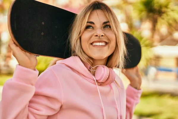 Junge Blonde Skaterin Lächelt Glücklich Und Hält Skate Der Stadt — Stockfoto