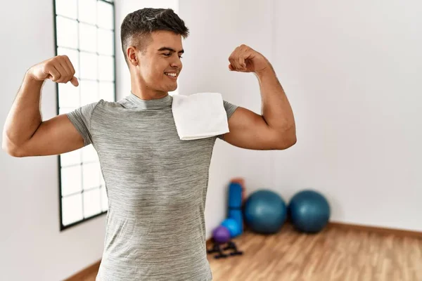 Young Hispanic Man Wearing Sportswear Towel Gym Showing Arms Muscles — Fotografia de Stock