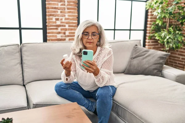 Mulher Meia Idade Usando Smartphones Segurando Pílulas Casa — Fotografia de Stock